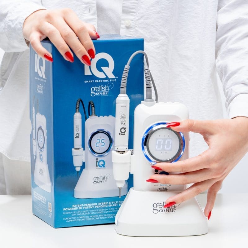 A woman showcases the Gelish Go File IQ Smart Electric File next to a box.