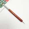 A KYE French Brush with Dotting Tool is sitting on top of a piece of paper.