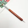 A KYE French Brush with Dotting Tool with a wooden handle for painting on paper.