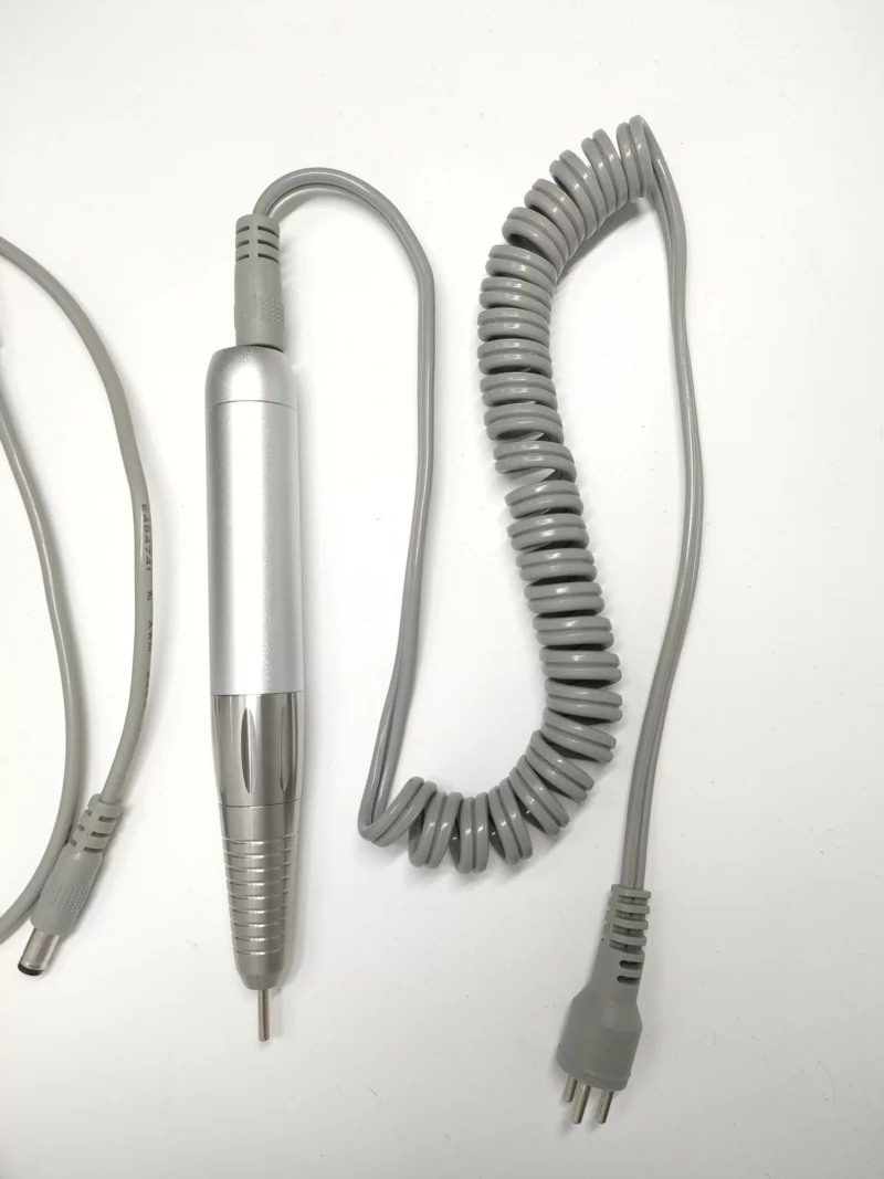 A coiled cord and a pair of wires on a white surface.