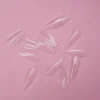 Transparent KYE Soft Gel Refill Tips - Long Coffin (50pcs/Bag) scattered on a pink background.