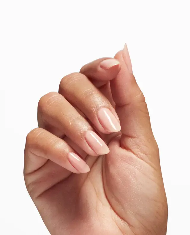 A close-up of a hand with neatly manicured nails featuring OPI Nail Envy Tri-Flex Technology 0.5oz against a white background.