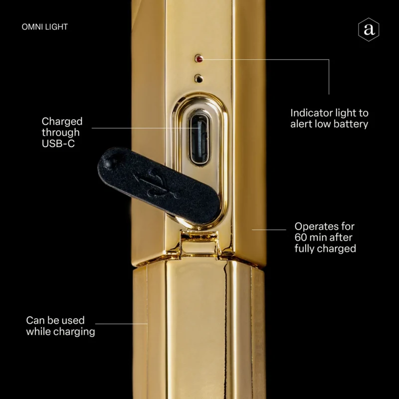 Close-up of a gold-toned Apres Gel-X Flash Cure Omni Light Gold with a USB charging port, indicator light for low battery, and a note that it can operate for 60 minutes after charging.