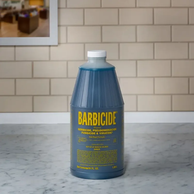 A bottle of Barbicide Half Gallons disinfectant on a marble countertop against a tiled backsplash.
Product Name: Barbicide Half Gallons