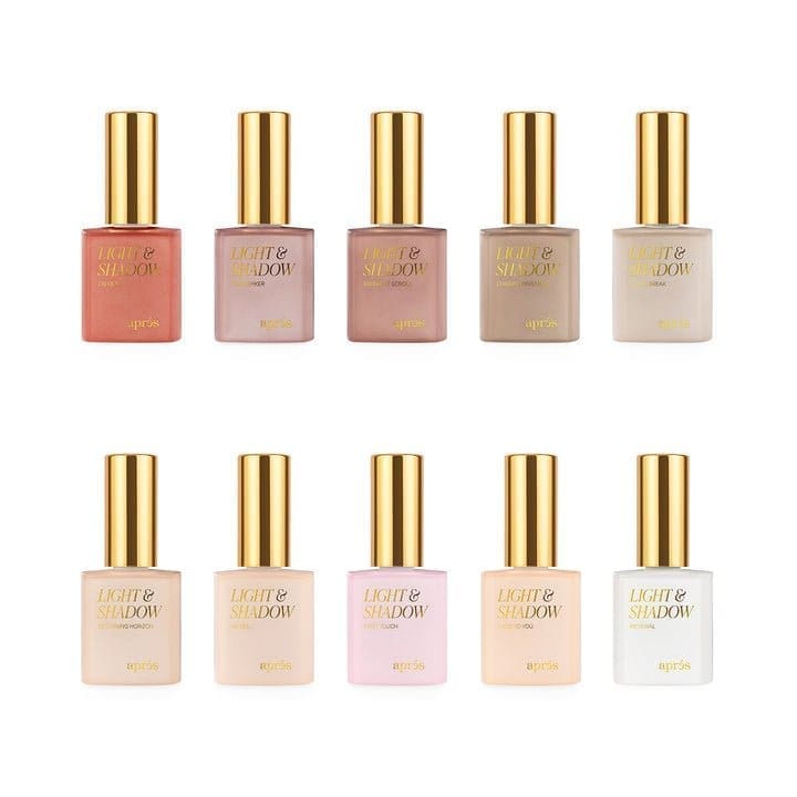 A set of ten bottles of Apres Light & Shadow Sheer Gel Collection 10ml with gold caps, each labeled "Light & Shadow" by Après, featuring a range of colors from dark red to light pink and beige.