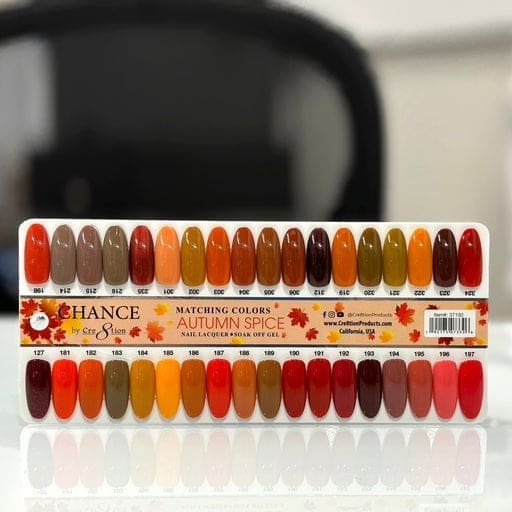 A display board showcasing 36 nail polish swatches labeled "CHANCE Matching Trio - Hello Autumn Collection." The colors range from browns and reds to oranges and yellows, each with individual identification numbers. Discover the enchanting hues for a perfect seasonal look.