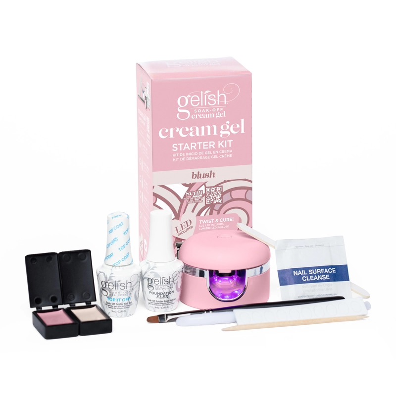 A nail kit including a pink LED lamp, nail cleanser wipes, three gel polish products, a brush, an orange stick, nail files, and a pink box labeled "Gelish Solid Cream Gel Polish Starter Kit - BLUSH".