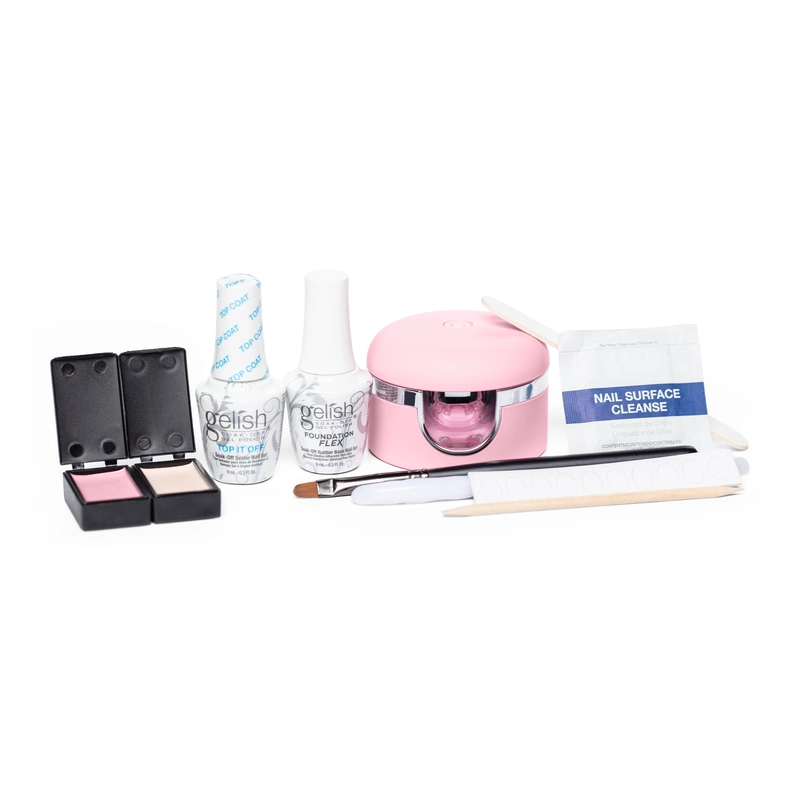 The Gelish Solid Cream Gel Polish Starter Kit - BLUSH features a comprehensive set of nail care products, including Gelish Solid Cream Gel Polish, nail surface cleanse, a nail lamp, various tools, and a box containing two elegant BLUSH nail colors.