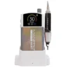 The "ManiPro Passport Next Complete White" portable manicure device, featuring a display that shows "30" and a connected handpiece, rests elegantly on its white charging base.