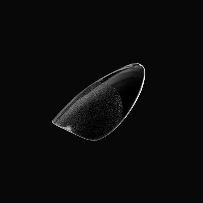 Close-up of a glossy, black object resembling a curved piece of glass or plastic, set against a solid black background, evoking the sleek elegance of refined Kupa ENRICHRx Sof Gel Tips 550ct. ALMONDLETTO designs.